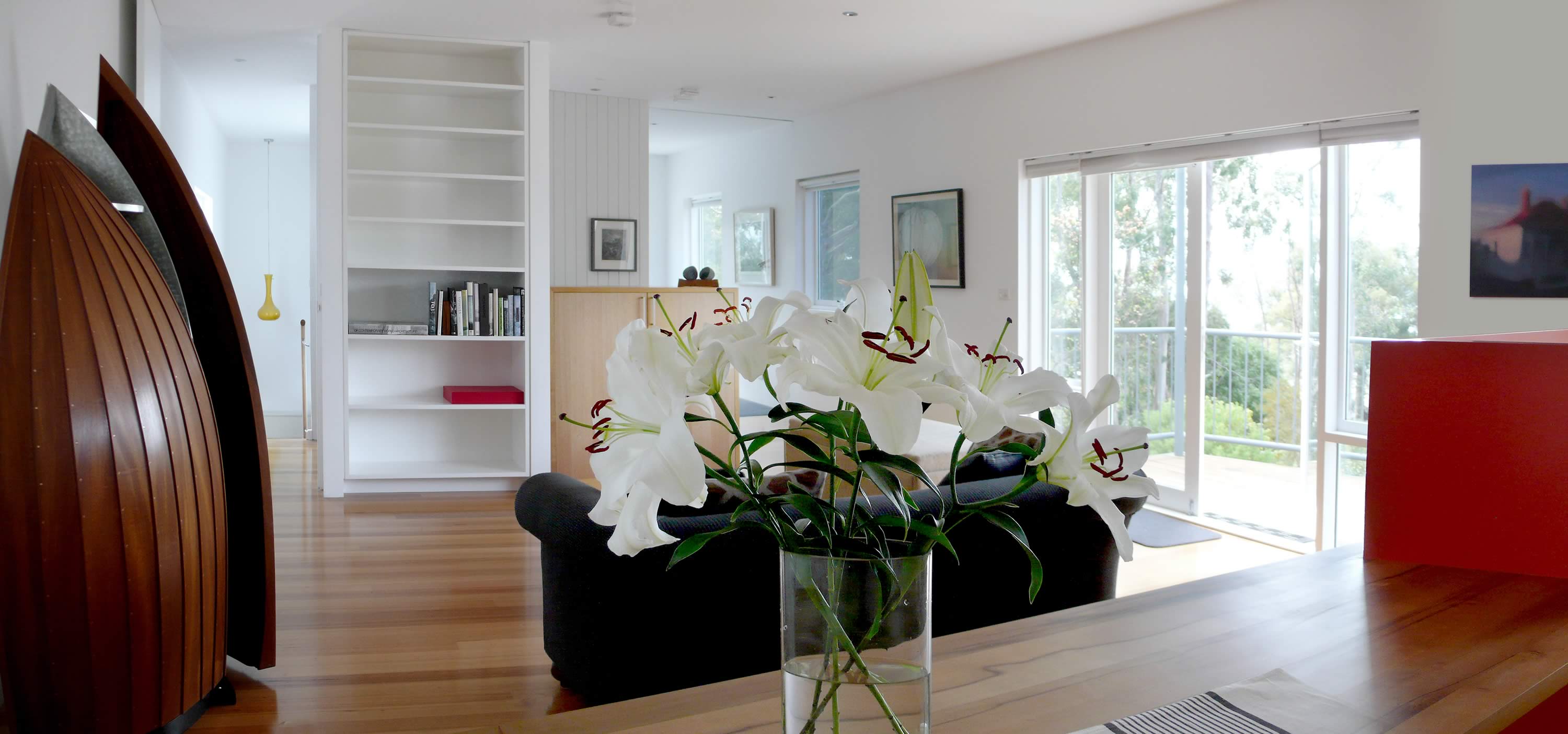 Photo showing the OUTSIDE THE BOX modern interior with white flowers in the foreground.