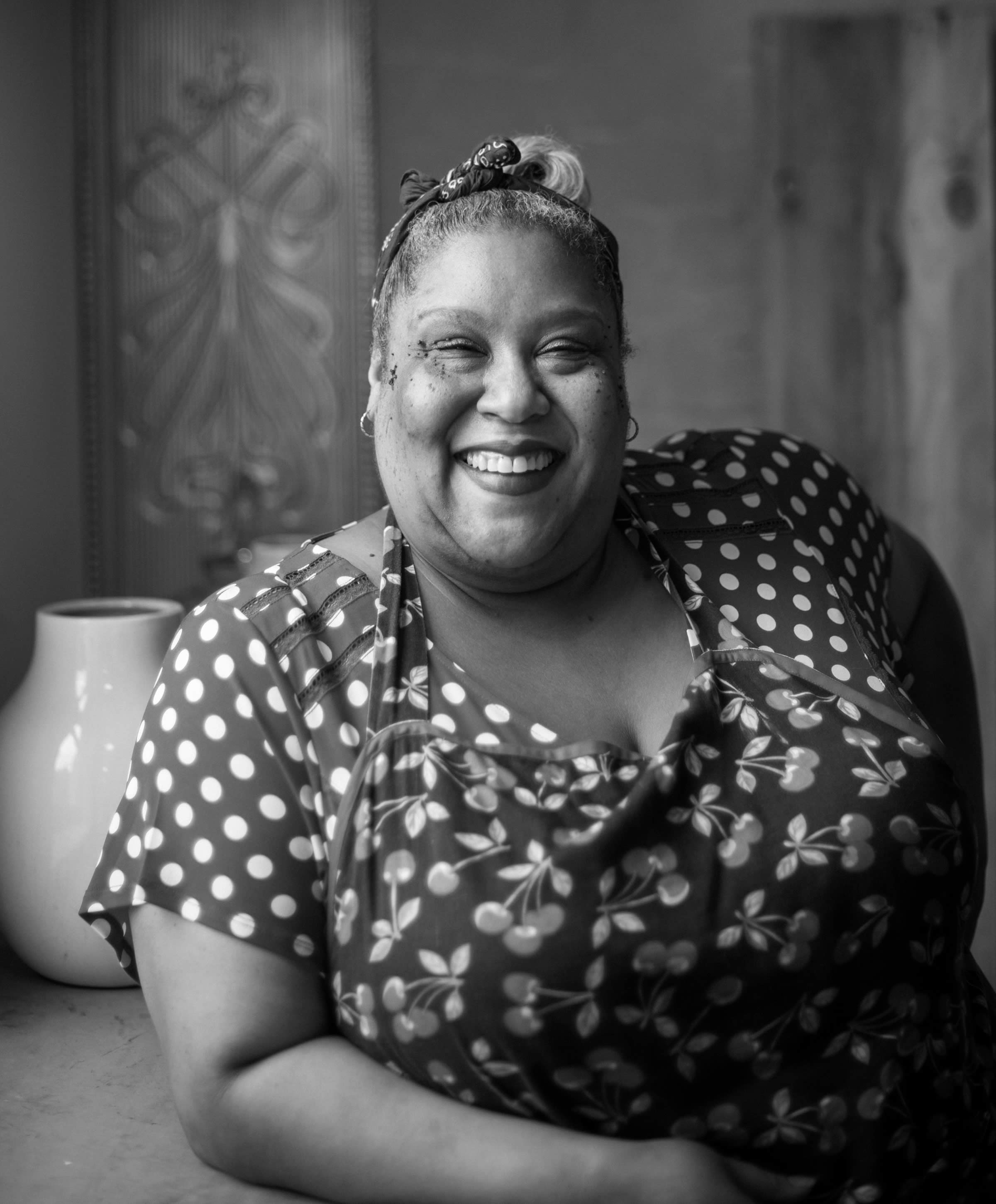 Black and white photo portrait of Honey Child, smiling broadly at the camera. Photo: Jonathan Wherrett.