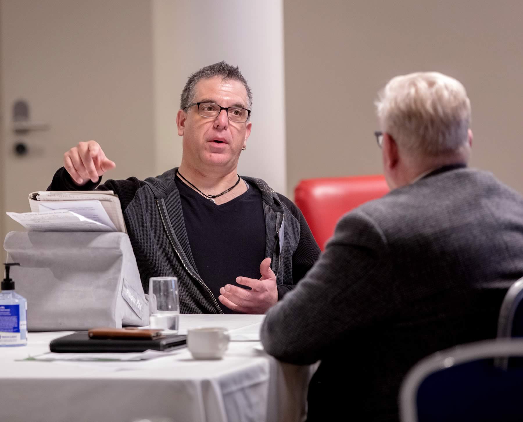 Photo of male participant in the Pitch Perfect workshop speaking to a journalist who has his back to the camera. Photo: Barefoot Photographer (Tasmania) – José Navarro