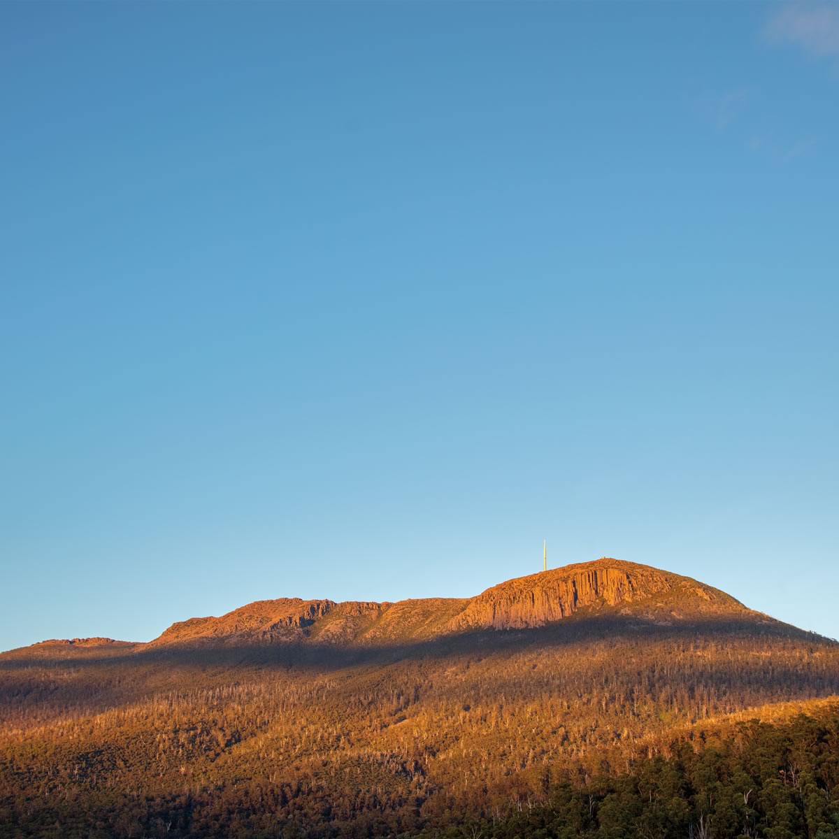 Photo of kunanyi / Mount Wellington under a bright blue sky. Image: Rob Blakers.