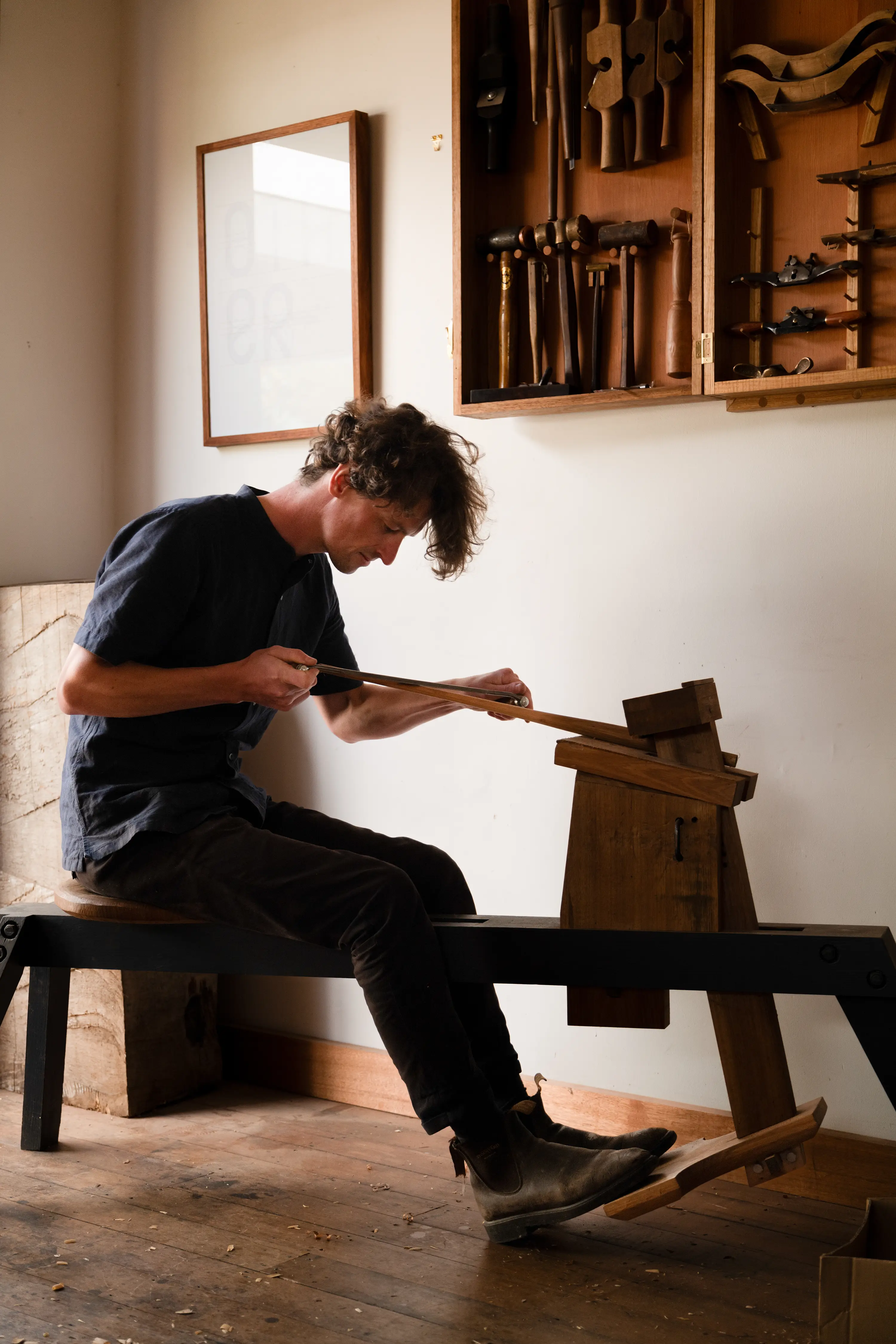 Image of furniture maker Ben Grieve-Johnson seated at a foot treadle hand-shaping a chair stay.