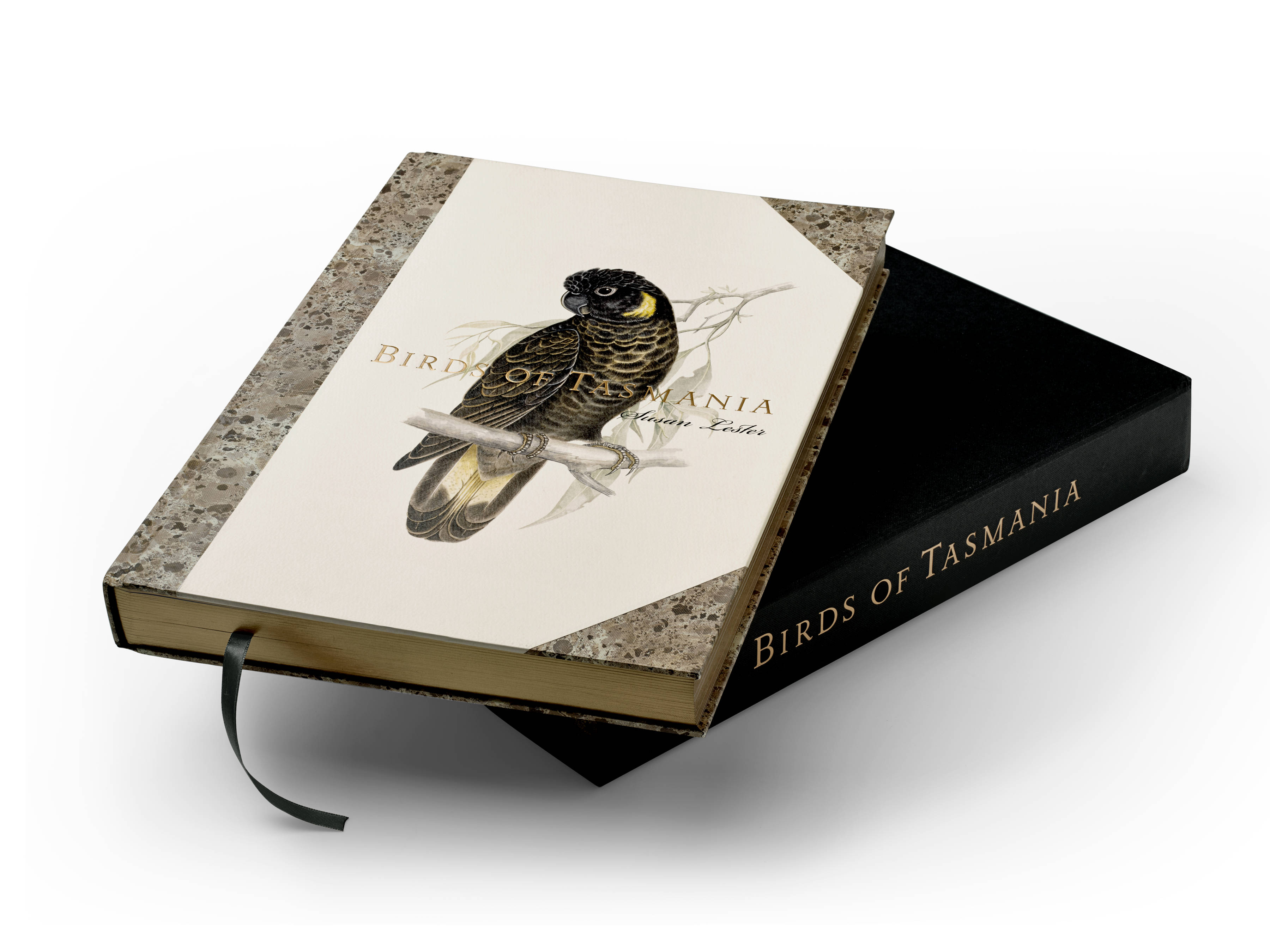 The Birds of Tasmania by Susan Lester book, with a Yellow-tailed Cockatoo ‘Zanda funerea’ and gold and black foil titling, sitting on the black clamshell presentation box.