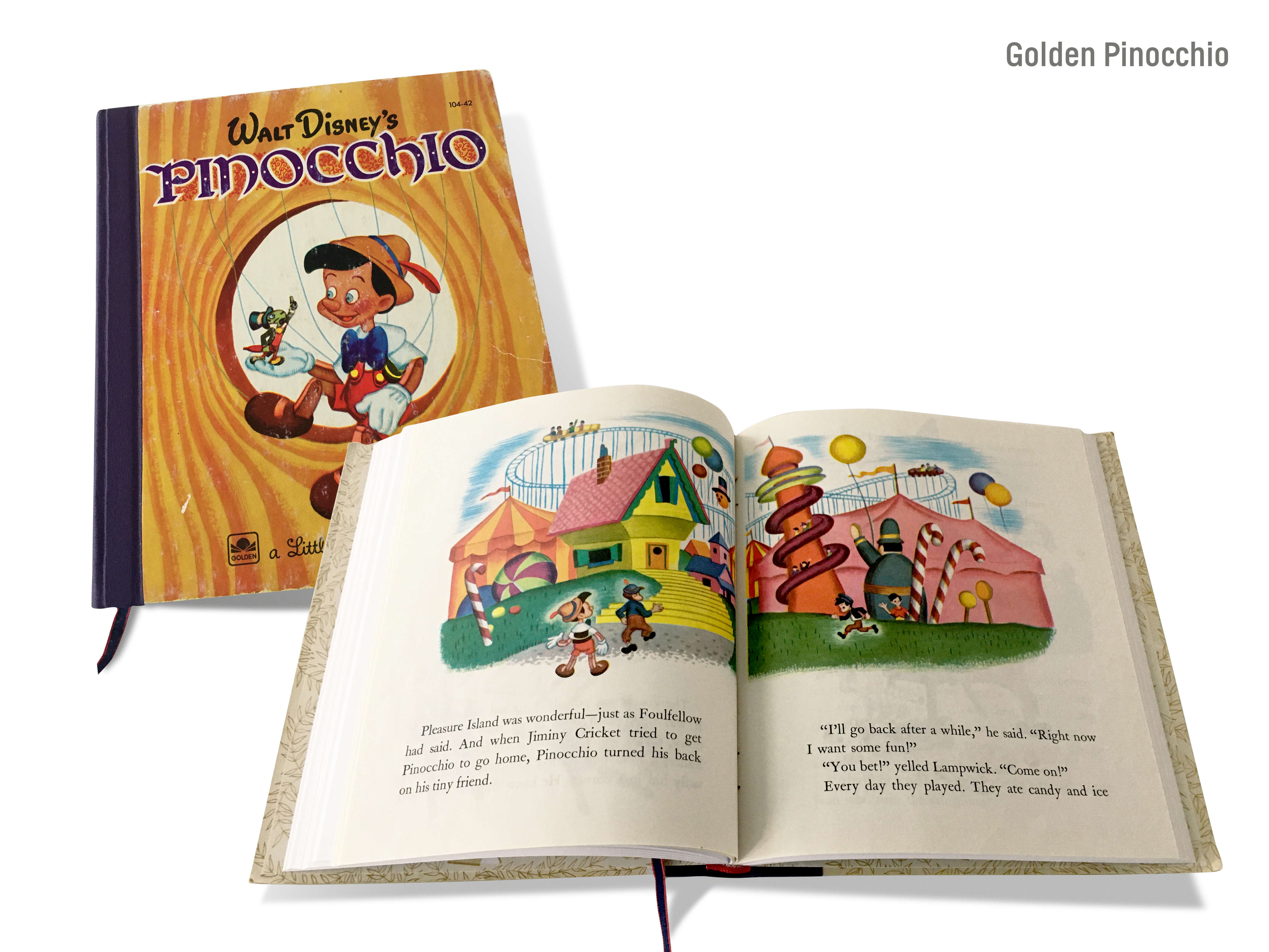 A montage image of a cover and a double-page spread of the hand-made journal titled, ‘Golden Pinocchio’ by Michael Small, featuring a Little Golden Book cover of ‘Walt Disney’s Pinocchio’ and a double-page spread showing drawings of Pinocchio at a funfair with roller-coaster rides, slippery dips, giant candy canes and balloons.