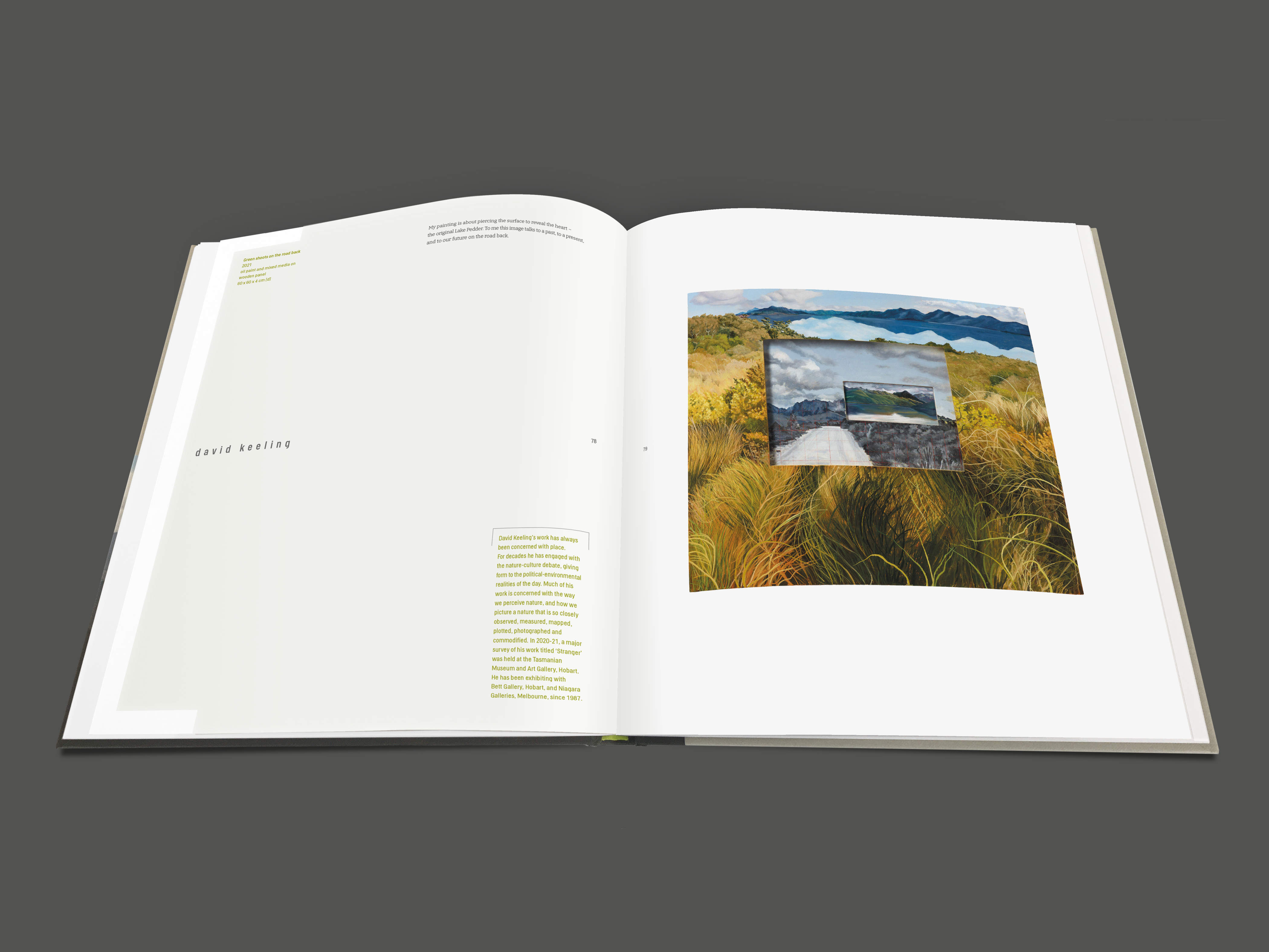 Image of a double-page spread from the water[shed] exhibition publication (pages 78 & 79). The left-hand page has an artist statement by David Keeling and details of his oil painting titled ‘Green shoots on the road back’ (2021). The right-hand page features David’s painting, which depicts three different landscape scenes. The main scene depicts the drowned landscape. The middle scene shows a section of the unsealed Scotts Peak Road with a topographic map grid overlay and rugged mountain ranges in the background. This references an earlier work titled, ‘The road back (inset after Olegas Truchanas)’ (2021). The third scene is a small inset image depicting the shallow water and beach of the original Lake Pedder before it was flooded.